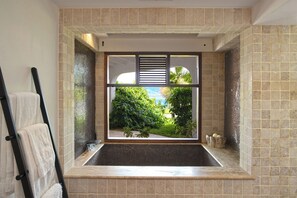 Ein Badezimmer mit großem Fenster, Handtuchhalter und Duschbereich.