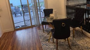 Ein Essbereich mit einer Chandelier, einem Glastisch und Stühlen.