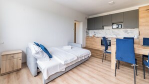 Une chambre à coucher moderne avec un lit, une table de chevet et une petite table de nuit en bois.