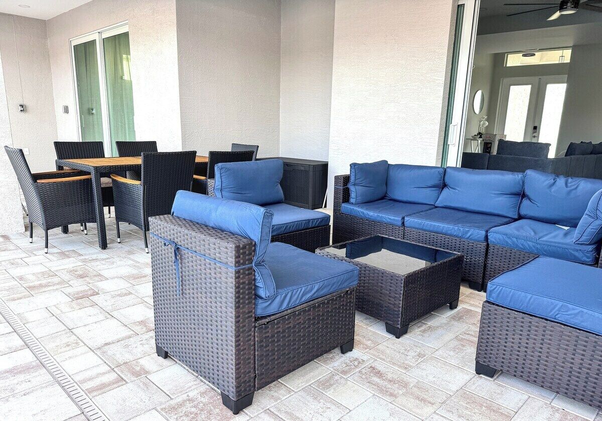 A patio area with wicker furniture, including sofas and chairs, and a table.