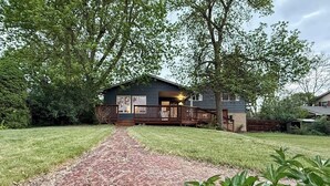 A house with a paved driveway leading to a front porch. - Sunny Retreat with Stunning Golf Course Views (Centennial)