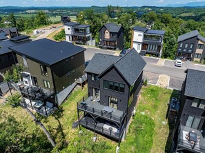 A residential area with modern houses, a paved road, and a clear view of the surrounding landscape. - Private pool, hot tub, luxury 4 bedrooms, walk in shower (Sevierville)