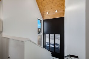 Eine Treppe mit Holzboden und einer schwarzen Wand mit drei gerahmten Bildern.