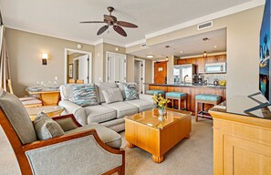 A living room with a sofa, coffee table, and a ceiling fan. - 7th-Floor Honua Kai 1BR with Ocean and Mountain Views (Lahaina)