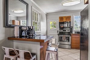 Una cocina con una isla central, armarios de madera, una estufa y un refrigerador.