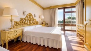 A hotel room with a large bed, two bedside tables, a chandelier, and a balcony with curtains. - A unique house in Roses, 975 m2, with an indoor pool and a 2,000 m2 garden (Roses)