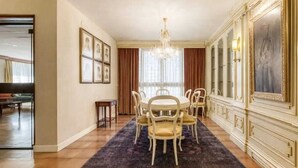 A dining area with a round table, chairs, a chandelier, framed artwork, and a large painting on the wall. - A unique house in Roses, 975 m2, with an indoor pool and a 2,000 m2 garden (Roses)