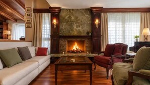 A living room with a fireplace, a sofa, a chair, and a coffee table. - A unique house in Roses, 975 m2, with an indoor pool and a 2,000 m2 garden (Roses)