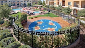 A residential complex with multiple apartment buildings, a swimming pool, and a landscaped garden area. - Vino Bello Resort - September 4 -7, 2026 (Napa)