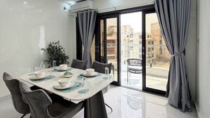 A modern dining room with a large table, chairs, and a view of the outside. - 401: 2-bedroom apartment in perfect Dakar with cool AC, fast WiFi and comfort (Dakar)
