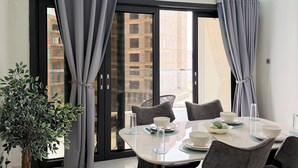 A modern dining area with a round table, grey chairs, and a potted plant. - 401: 2-bedroom apartment in perfect Dakar with cool AC, fast WiFi and comfort (Dakar)
