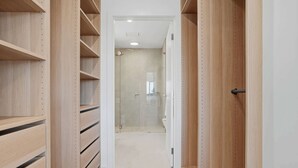 A walk-in closet with wooden shelving and a door leading to a bathroom. - Woodlands Escape - 3 Bed, 2.5 Bath, Near Winery (Orange)