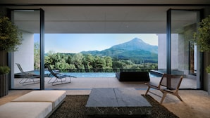 Un área de estar moderna al aire libre con piscina, con vistas a un paisaje montañoso.