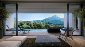 Un espace extérieur moderne aménagé avec des sièges et une piscine, offrant une vue sur un paysage montagneux.