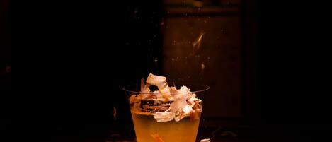 Un vaso con una bebida y un papel encima, sobre una superficie de madera.