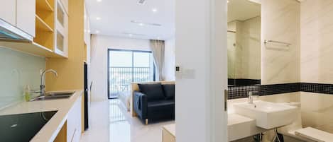 A modern kitchen with a black countertop, a black sofa, and a large window.