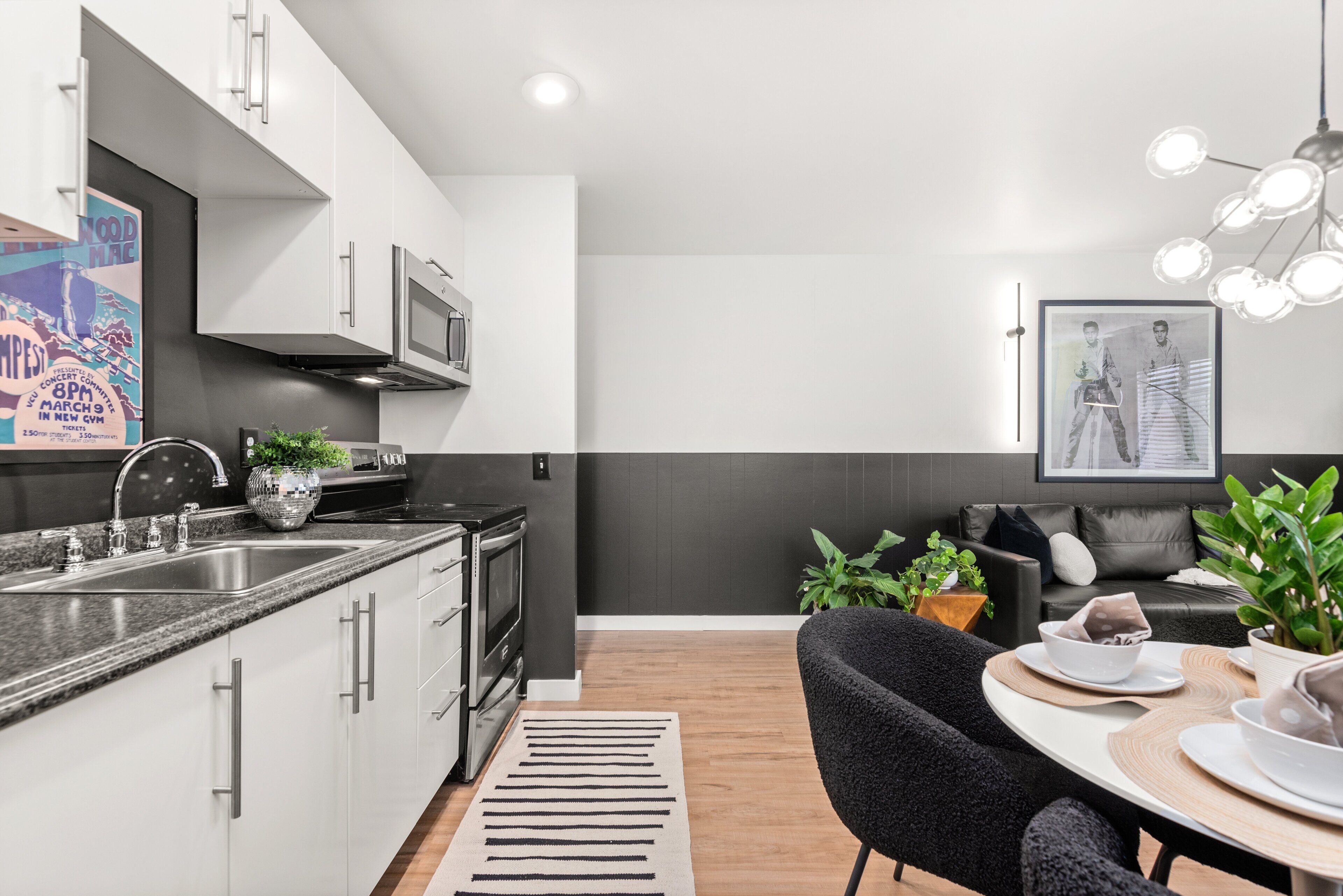 A modern kitchen with white cabinets, a black countertop, and a built-in oven.