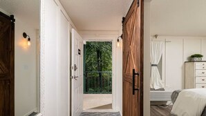 Een slaapkamer met een bed, een kaptafel en een raam met gordijnen.