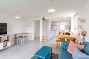 A modern apartment with a living room, dining area, kitchen, and a TV. - Lovely Sea View 2BDR Flat in Edinburgh (Edinburgh)