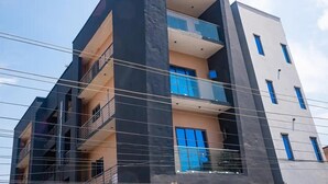 A multi-story building with balconies and a modern architectural design. - City-Chic Ikeja 2BR Escape: 24/7 Power, Fast WiFi, Airport, Shops & Eats - Lagos (Ikeja)