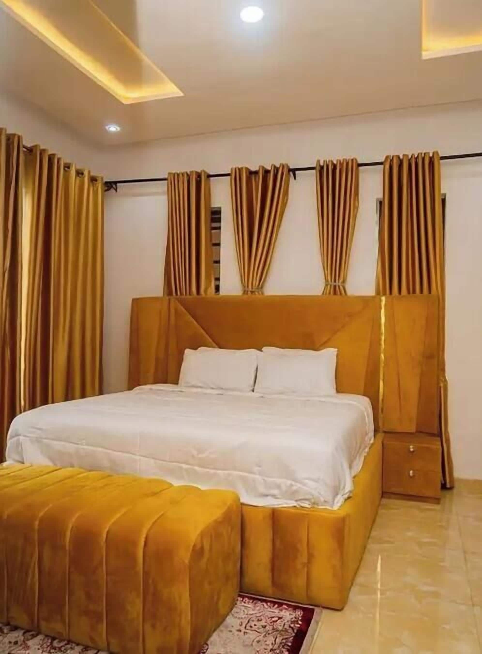 Une chambre à coucher avec un grand lit, une table de chevet et une commode.