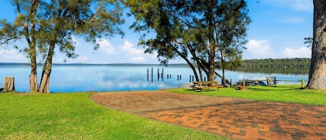 Un parc au bord du lac, équipé de tables de pique-nique et d’une promenade aménagée.