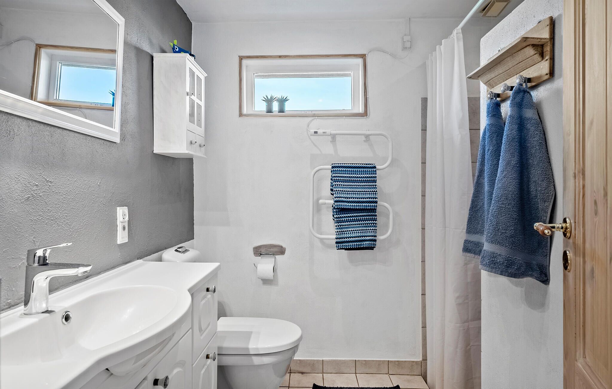 Ein Badezimmer mit Waschbecken, Toilette und Duschbereich.