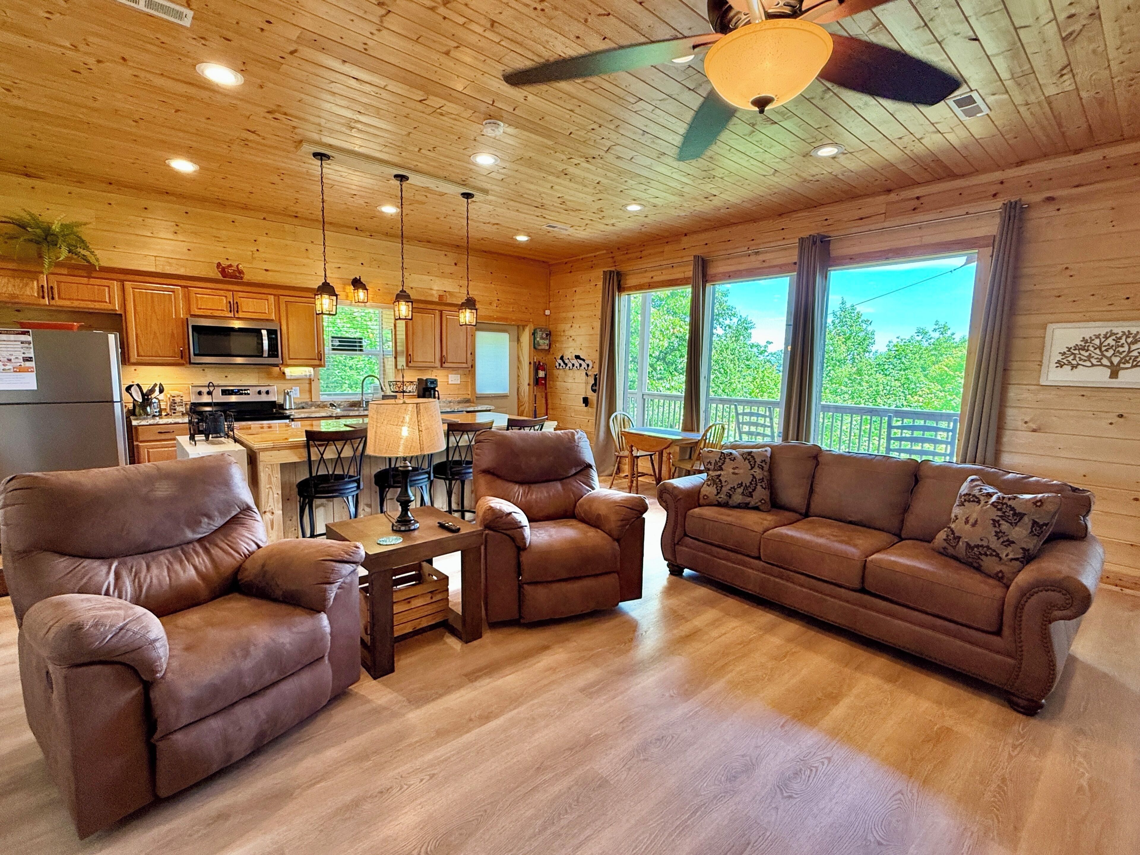 A cozy cabin interior with a dining area, kitchen, and seating with a view.