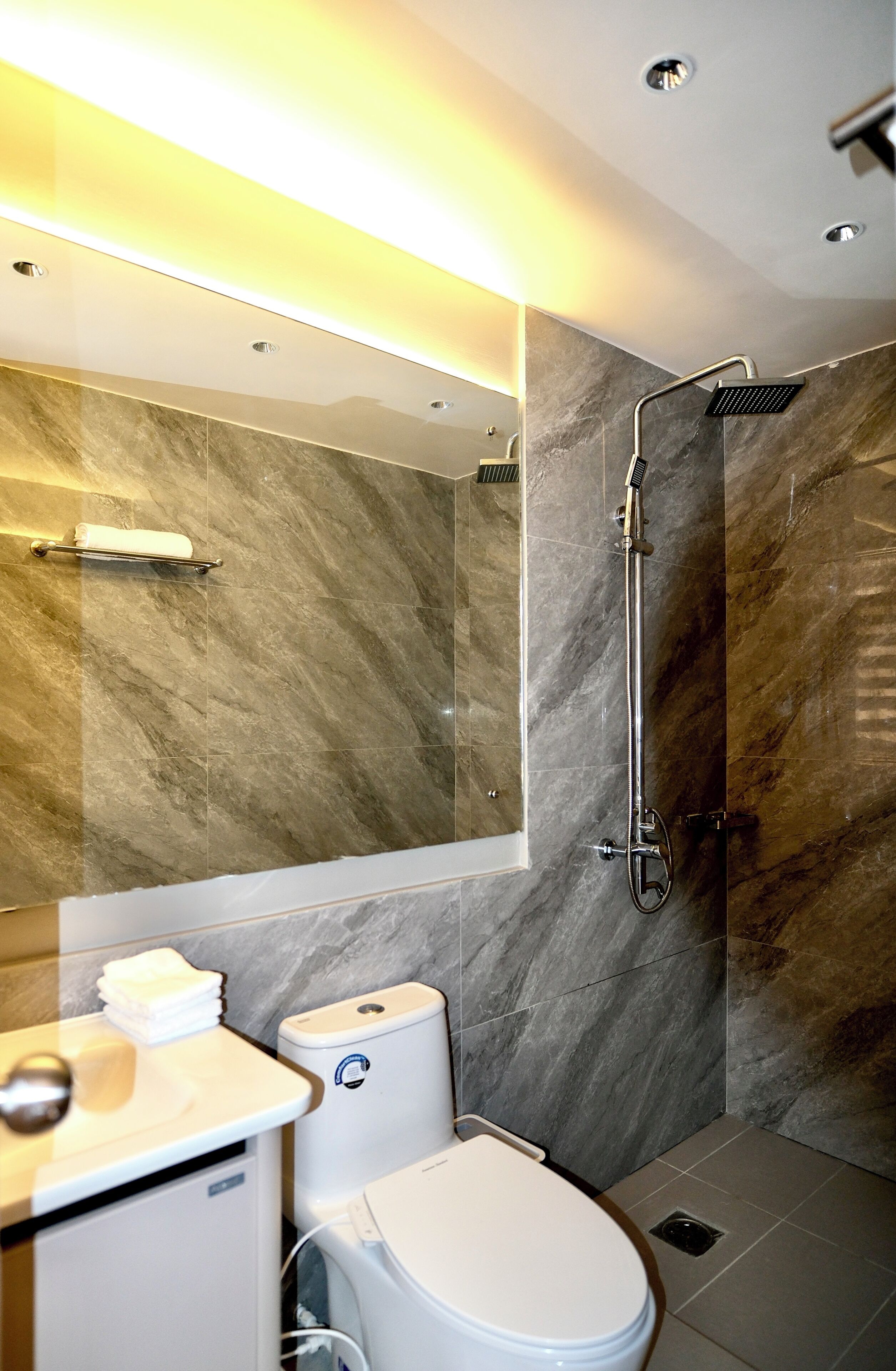 A modern bathroom with a shower, toilet, and sink.