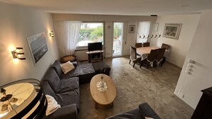 Ein Wohnzimmer mit einer Couch, einem Couchtisch und einem Essbereich mit Stühlen.