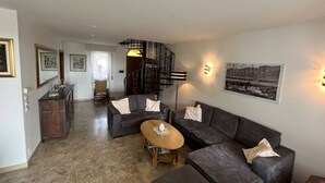 Ein Wohnzimmer mit einer Couch, einem Couchtisch und einer Treppe.