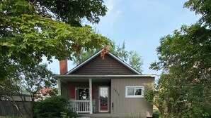 Une maison d’habitation avec un porche à l’avant, le numéro « 1038 » bien visible sur le mur, et un chemin menant à l’entrée.
