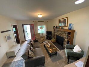 A living room with a sofa, armchair, coffee table, fireplace, and a television. - Steps to Lake Huron • Near Mackinac Ferry • Central AC (St. Ignace)