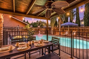 Un espace extérieur aménagé pour les repas, avec une piscine, une terrasse en bois et un patio clôturé.