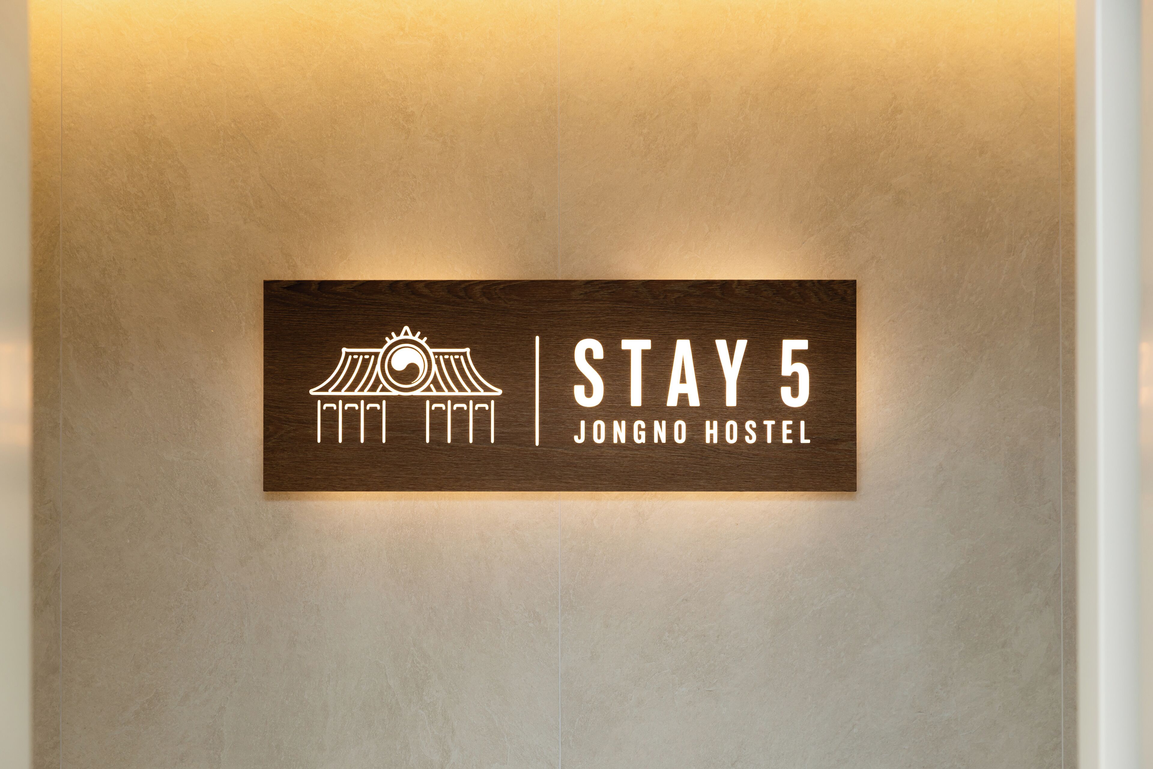 Um letreiro com um logotipo e o texto 'STAY 5 JONGNO HOSTEL'.