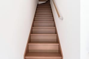 A wooden staircase with a handrail on the right side. - HANASTAY UMI (Osaka)