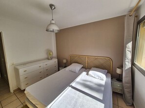 A bedroom with a bed, a dresser, a bedside table, a lamp, and a ceiling fan. - Sea view, 4 sleeps, all on foot (ST MANDRIER SUR MER)