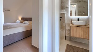 Ein Schlafzimmer mit einem Bett, einem Nachttisch und einem Beistelltisch.