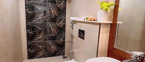 A modern bathroom with a toilet, bidet, sink, and a mirror.