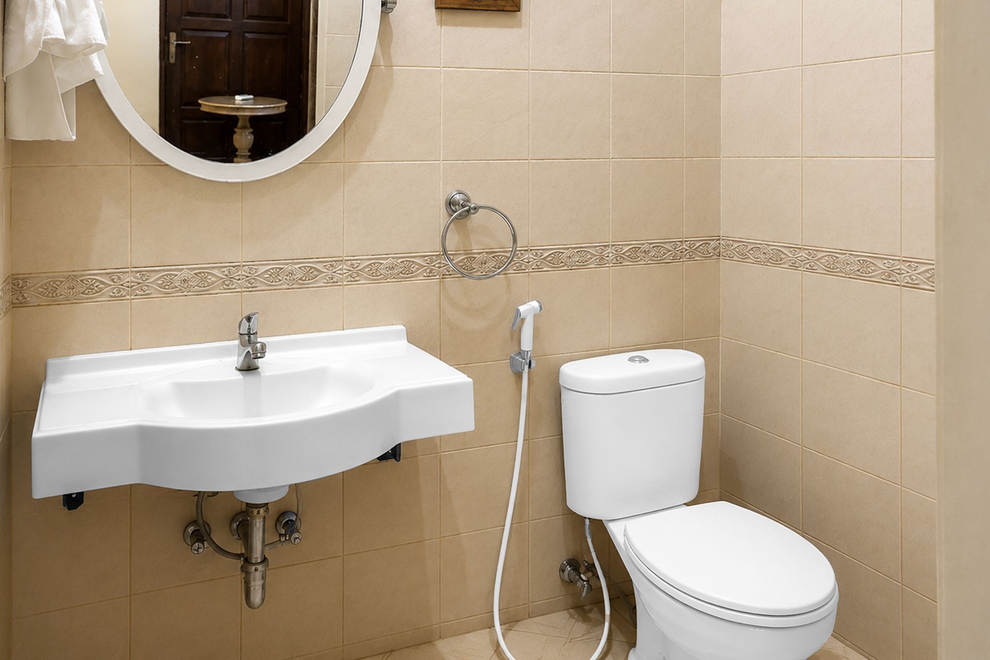 A bathroom with a white sink, a toilet, and a mirror.