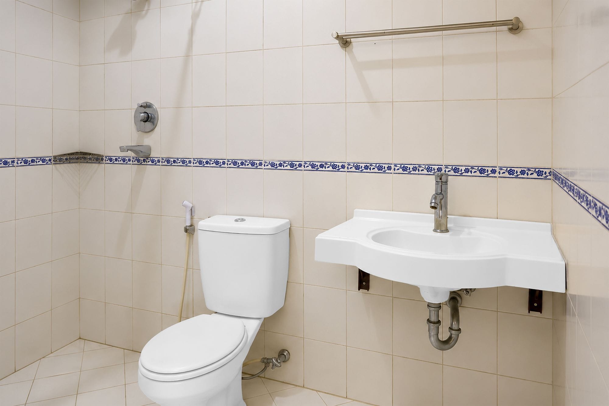 A bathroom with a toilet, sink, and a grab bar.