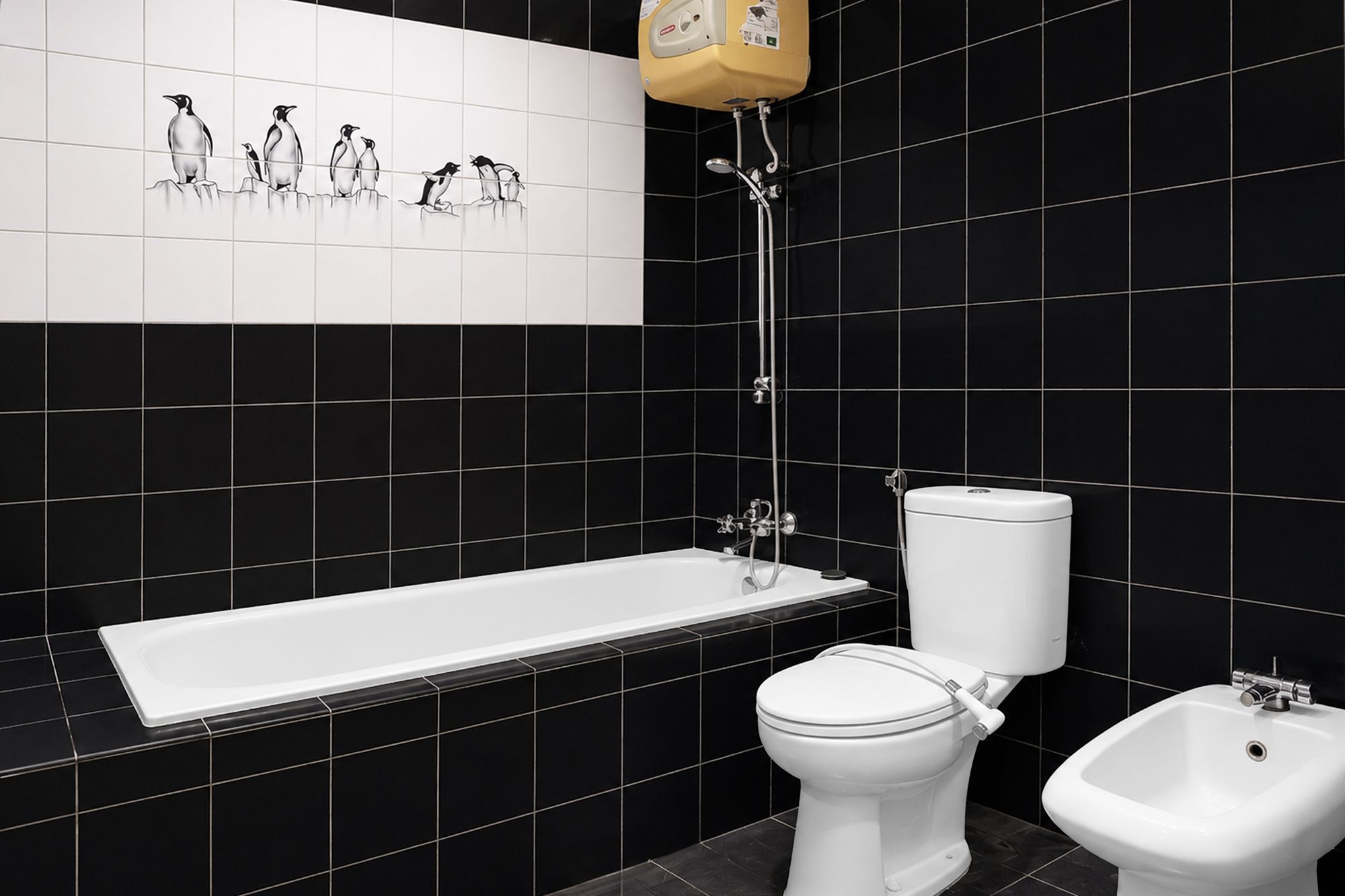 A bathroom with a white bathtub, a white toilet, and a bidet.