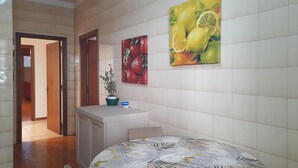 A hotel room with a bed, a small desk, a potted plant, and two fruit-themed paintings on the wall. - Awesome apartment in Maglie with WiFi (Maglie)
