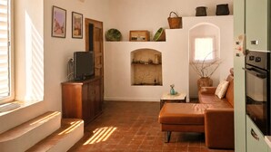A living room with a television, a sofa, a small table, and a fireplace. - Cozy home in Militello in Val di Ca with WiFi (Militello in Val di Ca)