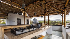 A kitchen with a gas stove, pots, and a view of the mountains.