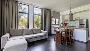 A modern living area with a sofa, dining table, and kitchen.