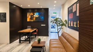 A modern hotel lobby with a reception desk, seating area, and a large abstract painting on the wall. - Suk41 (Bangkok)