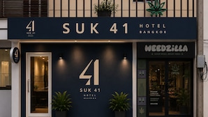 The exterior of Suk 41 Hotel in Bangkok, featuring a prominent number '41' sign, a storefront for Weedzilla, and potted plants at the entrance. - Suk41 (Bangkok)