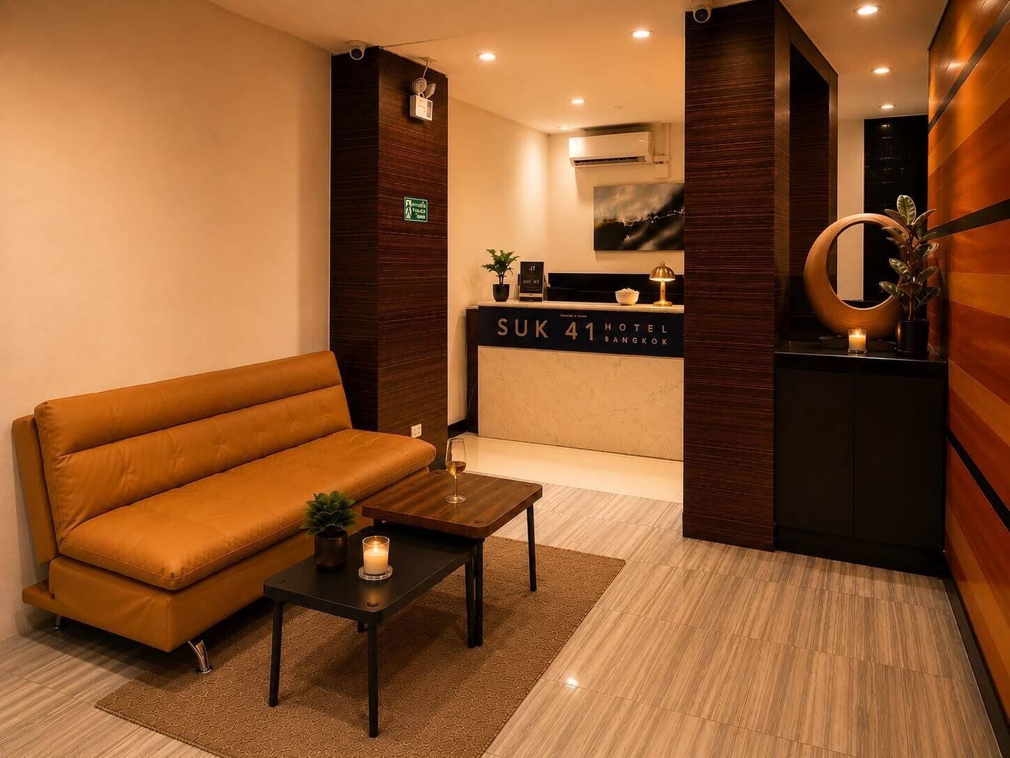 Zona de recepción de un hotel con un sofá, un mostrador de recepción y una unidad de aire acondicionado mural.