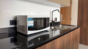Departamento de lujo, vista a la alberca, planta baja | Cocina privada | Refrigerador, microondas y utensilios de cocina
